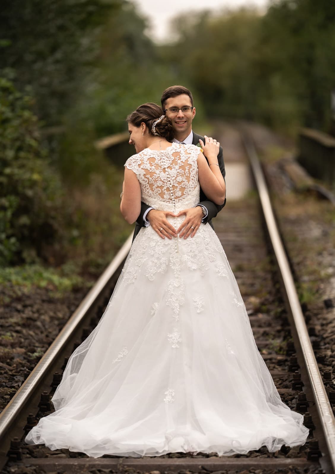 Brautpaar in bayerischer Tracht steht im Türrahmen eines alten Bauernhofs