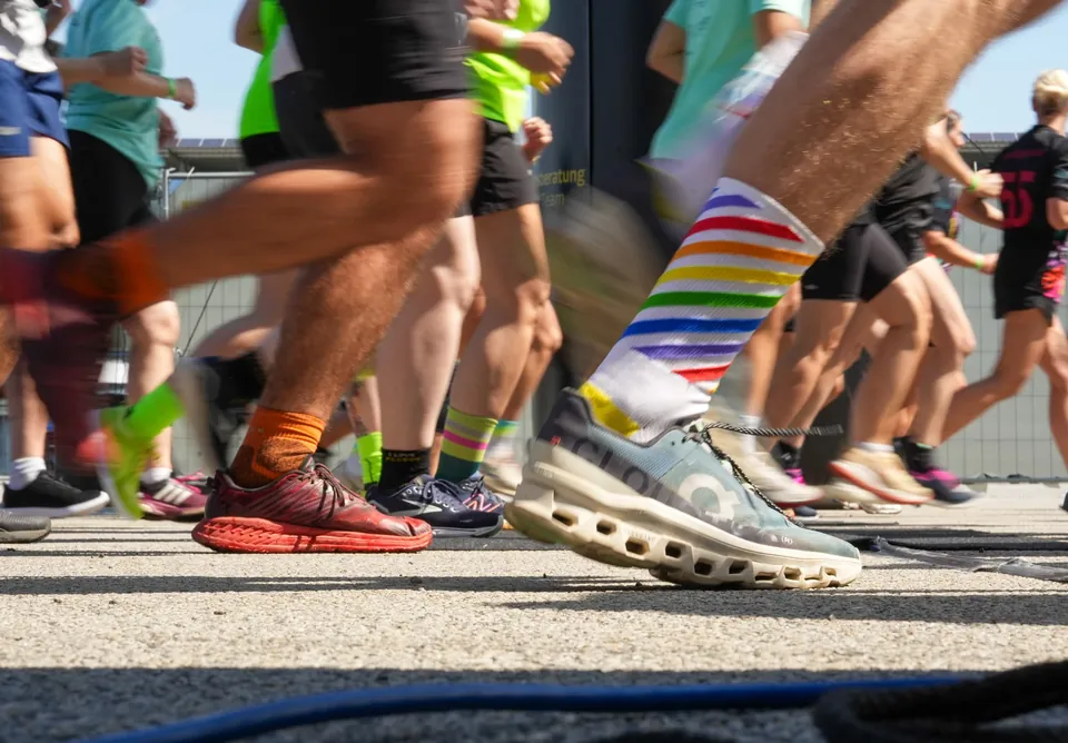 Laufschuhe und Beine mehrerer Teilnehmer eines Hindernislaufs.